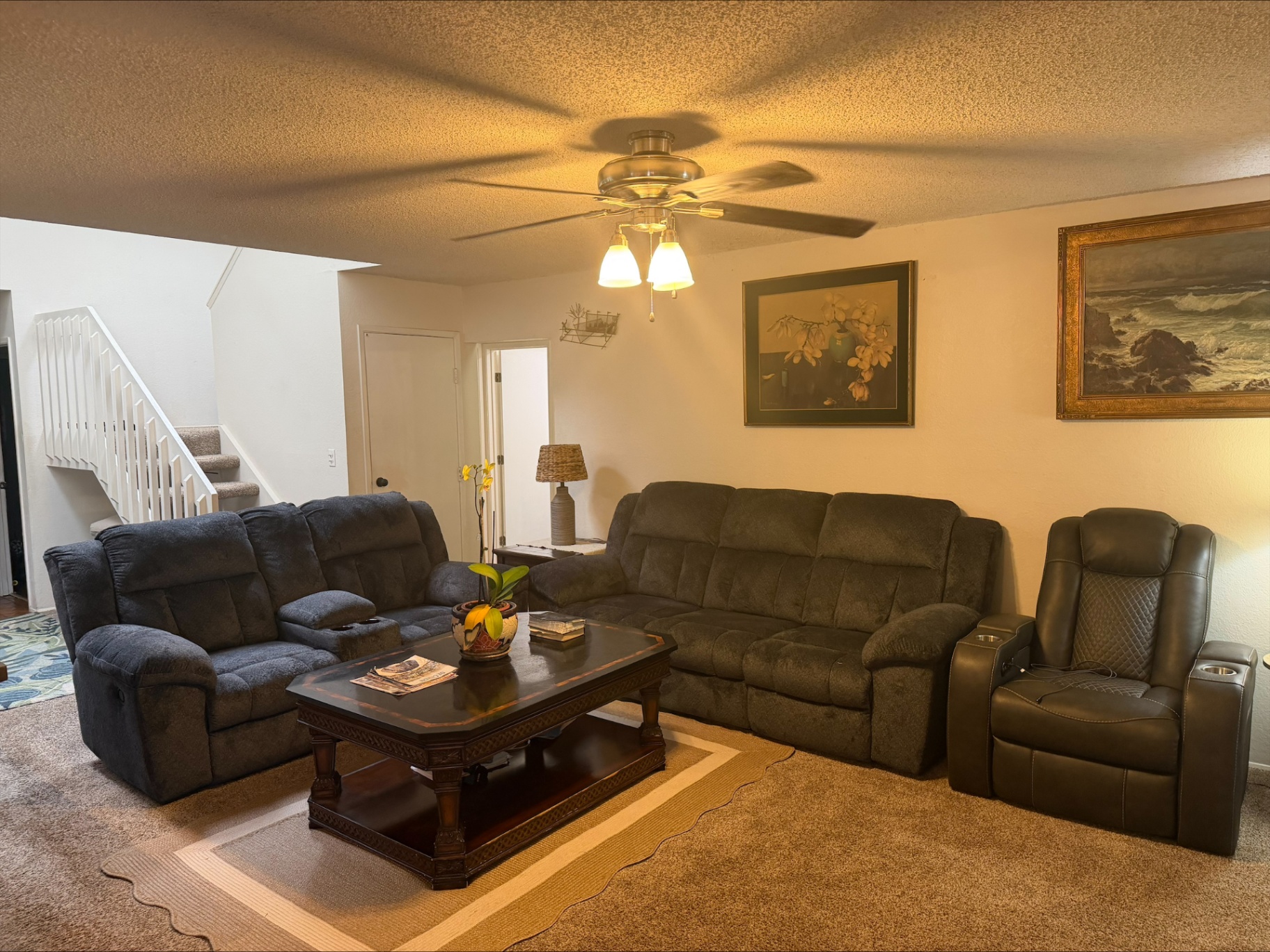 Comfortable living room with recliners, sofa, and family artwork